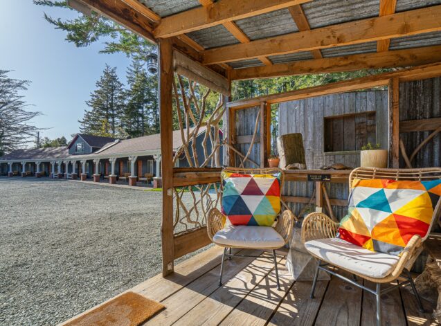 photo of a bandon hotel outdoor seating area with rattan chairs that have white cushions and colorful orange and blue and white accent pillows